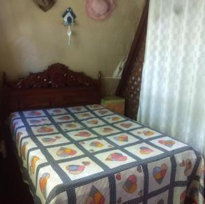 Una cama con edredón en un dormitorio en Casa na Floresta em Campos do Jordao, en Campos do Jordão