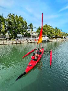two people in a red boat with a sail on the water at Captain's Quarters Marathon in Marathon