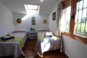 Cette chambre comprend 3 lits et une fenêtre. dans l'établissement El paraíso tropical en Málaga, à Alhaurín de la Torre