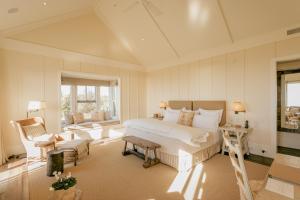 a bedroom with a large bed and a chair at Rosewood Cape Kidnappers in Te Awanga