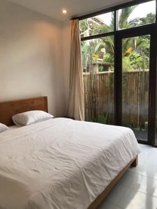 ein Schlafzimmer mit einem Bett und einem großen Fenster in der Unterkunft De, dalam secret nature in Ubud