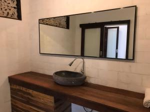 ein Badezimmer mit Waschbecken und Spiegel in der Unterkunft De, dalam secret nature in Ubud + 21 Fotos