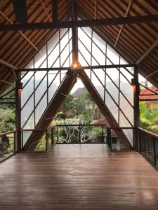 ein großes Gebäude mit Holzboden und Fenstern in der Unterkunft De, dalam secret nature in Ubud