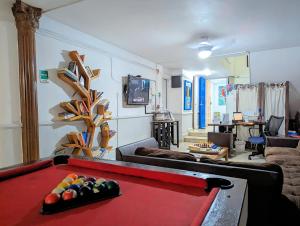 una sala de estar con una mesa de billar rojo. en Hostal Yoha, en Panamá