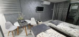 ポドゴリツァにあるCozzy apartment near the Aiport Podgoricaのベッドルーム1室(ベッド2台、テーブル、テレビ付)