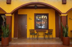 ein gelbes Haus mit einem Tisch und zwei Stühlen in der Unterkunft Estancia 104 in La Paz