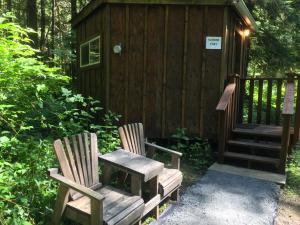 two chairs and a bench in front of a cabin at Alexander's Lodge in Ashford