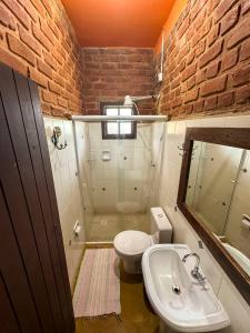 a bathroom with a white toilet and a sink at Alecrim Pousada in Conceição da Ibitipoca