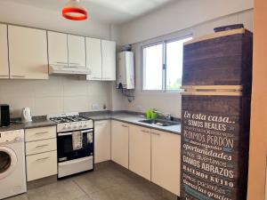 維森特洛佩斯的住宿－Tu departamento en Vicente López，厨房配有白色橱柜和炉灶烤箱。