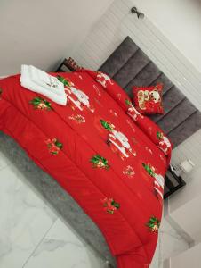 - une couverture rouge avec des décorations de Noël sur un lit dans l'établissement Maison Carrozzelle, à Naples