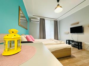 Habitación con 2 camas y mesa con lámpara amarilla. en Barbie Studio, en Sofía