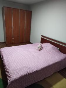 a bedroom with a pink bed with a stuffed animal on it at Apartman Leki in Sarajevo