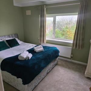 a bedroom with a bed with towels and a window at Private Entire House - 3 Bedrooms Garden Parking in Rottingdean