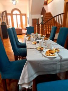 una mesa larga con platos de comida y sillas azules en Antigua Viña Bed and Breakfast, en Viña del Mar