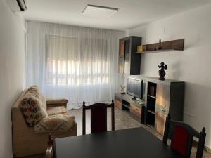 uma sala de estar com uma mesa e uma televisão em Apartamento Diagonal em Nules