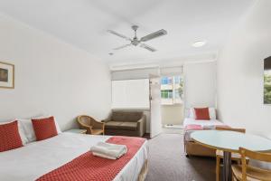 Adelaide的住宿－Taft Apartments，客房设有两张床、一张桌子和一张沙发。
