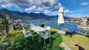 a table and chairs with an umbrella and a lake at LA VILLA by luxury Attilan in San Pedro La Laguna