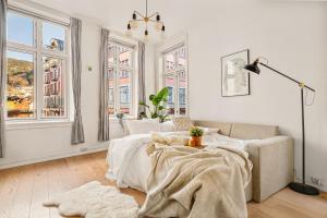 a white living room with a bed and windows at Live in historic building - View to Bryggen in Bergen