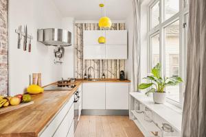 cocina con armarios blancos y encimera de madera en Live in historic building - View to Bryggen, en Bergen