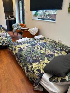 Bespoke Gallery guesthouse في هيندون: غرفة نوم مع سرير وبطانية ملونة