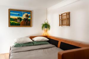 Casa Aurora - bairro típico a minutos do Terreiro في لشبونة: غرفة بها أريكة ولوحة على الحائط +4 صور