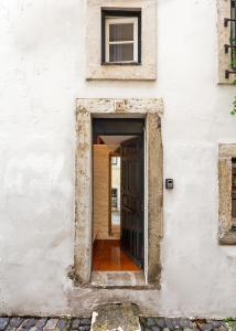 an entrance to a white building with a door at Casa Aurora - bairro típico a minutos do Terreiro in Lisbon