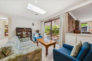 a living room with two couches and a table at Rosella Retreat in Blackheath