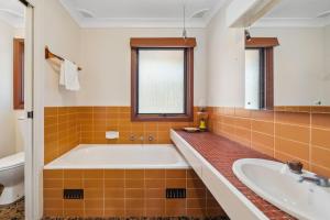 ein großes Badezimmer mit Badewanne und Waschbecken in der Unterkunft Rosella Retreat in Blackheath + 12 Fotos