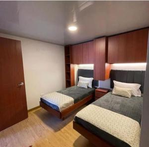 ein Hotelzimmer mit 2 Betten und einer Tür in der Unterkunft VILLA DE MOYA HOTEL MONGUI in Monguí