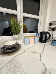 a kitchen counter with a window and some dishes on it at Studio near Heathrow in West Drayton