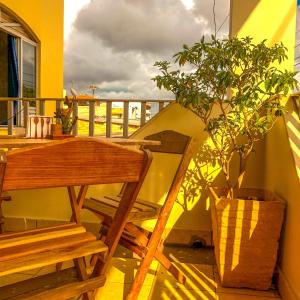 a wooden table and chair on a balcony with a potted plant at Pousada Casa do Ivo Santarém in Santarém