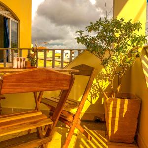 una mesa de madera y una silla en un balcón con una maceta en Pousada Casa do Ivo Santarém, en Santarém