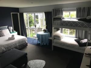 a bedroom with two bunk beds and a window at Sandy Feet Accommodation in Christchurch