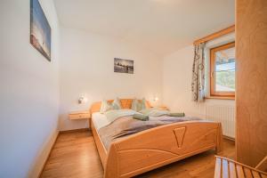 a bedroom with a wooden bed in a room at Appartements Gamper - Alpline Appartements KG in Brixen im Thale