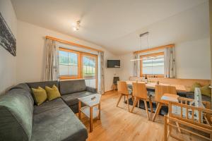 a living room with a couch and a dining room at Appartements Gamper - Alpline Appartements KG in Brixen im Thale