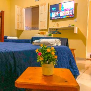 a hospital room with two beds and a table with flowers at Pousada Casa do Ivo Santarém in Santarém