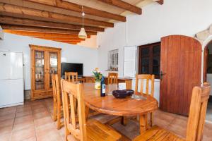 eine Küche und ein Esszimmer mit einem Holztisch und Stühlen in der Unterkunft Can Rovet in Port d'Alcúdia