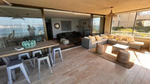 sala de estar con sofá, mesa y sillas en Depto de lujo en Punta Fraile, frente mar, 140 m2, amplias areas verdes, piscina, hamaca, tranquilidad en Algarrobo