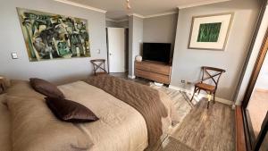 a bedroom with a bed and a flat screen tv at Depto de lujo en Punta Fraile, frente mar, 140 m2, amplias areas verdes, piscina, hamaca, tranquilidad in Algarrobo