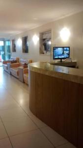 eine Lobby mit einer Bar mit Flachbildfernseher in der Unterkunft Apartamento aconchegante no centro de São Lourenço 700m do Parque das Águas in São Lourenço