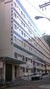 ein großes Gebäude mit einem davor geparkten Auto in der Unterkunft Apartamento aconchegante no centro de São Lourenço 700m do Parque das Águas in São Lourenço