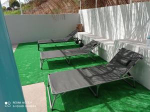 two chairs and a table on a green floor at Recanto D'nha Fana in Porto Novo