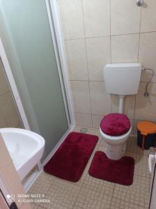 a bathroom with a toilet and a tub and a sink at Recanto D'nha Fana in Porto Novo