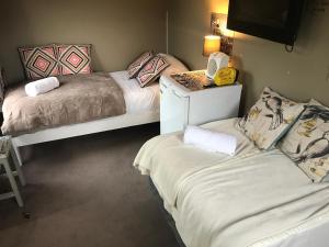 a bedroom with two beds and a phone on a table at Sandy Feet Accommodation in Christchurch