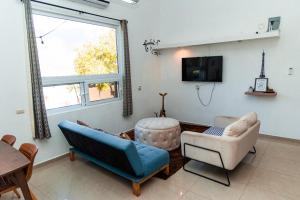 LA VILLA by luxury Attilan في سان بيدرو لا لاغونا: غرفة معيشة مع كرسيين وتلفزيون