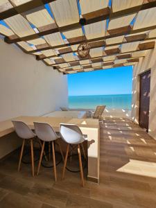 un comedor con mesa y sillas y el océano en Penthouse en Chicxulub, en Chicxulub