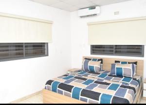 sypialnia z łóżkiem i 2 oknami w obiekcie Ibadan Serviced Apartments w mieście Ibadan