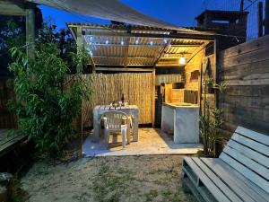 a backyard patio with a table and a kitchen at Lunas del Bosque Cabaña y apartamento en suite in La Paloma