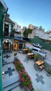 een patio met tafels, stoelen en bloemen voor een gebouw bij Hotel Boutique Calash in Mar del Plata