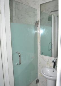 イバダンにあるIbadan Serviced Apartmentsのバスルーム(ガラス張りのシャワー、シンク付)